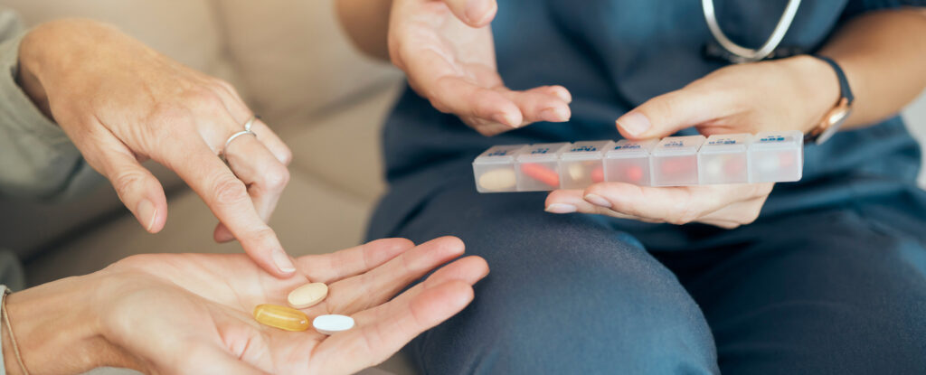 Close-up of a healthcare professional assisting a patient with daily medication management, highlighting the patient-centered approach advocated by Dr. Jai Bhagwan Dhull, expert in cardiothoracic and vascular care.