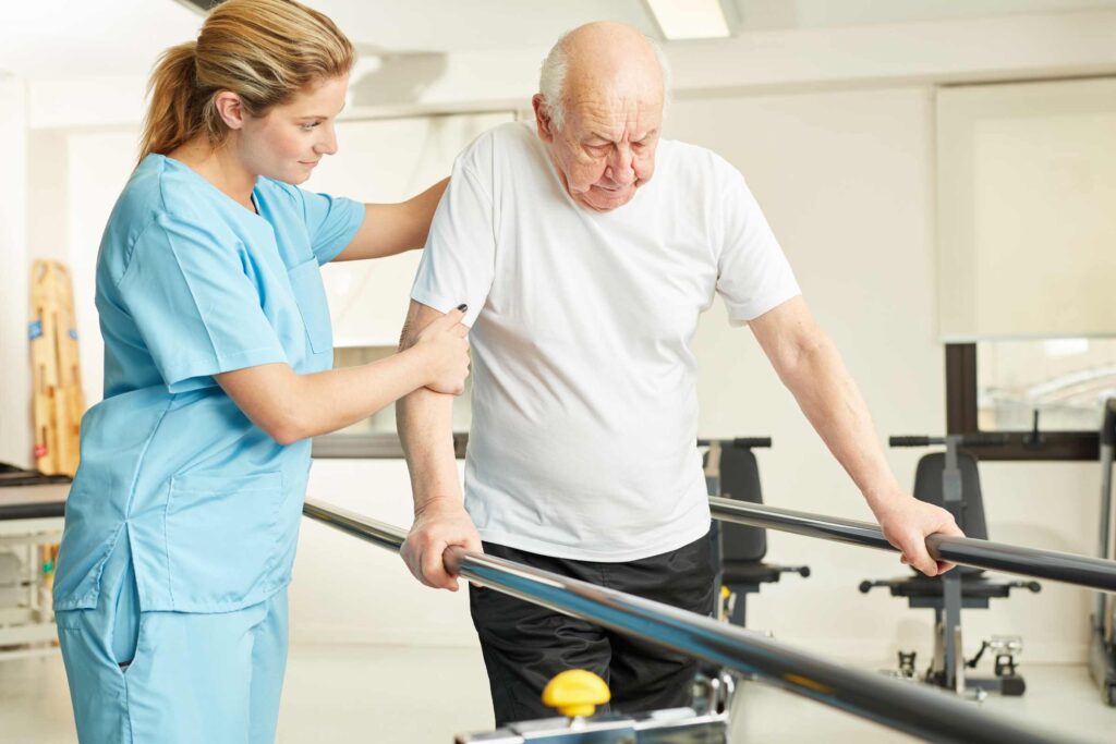 "Physiotherapist assisting an elderly man with walking exercises in a rehabilitation center, demonstrating the patient-focused care approach of Dr. Jai Bhagwan Dhull."