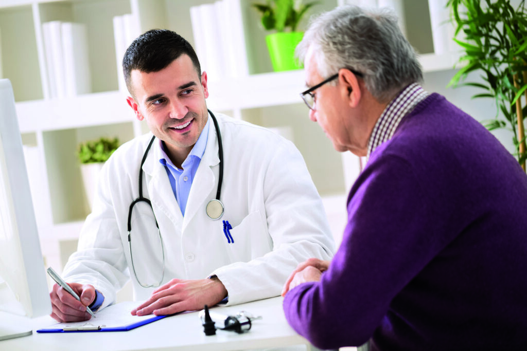 Doctor consulting with an elderly male patient in a clinic setting, representing compassionate patient care by Dr. Jai Bhagwan Dhull, cardiothoracic and vascular surgeon.