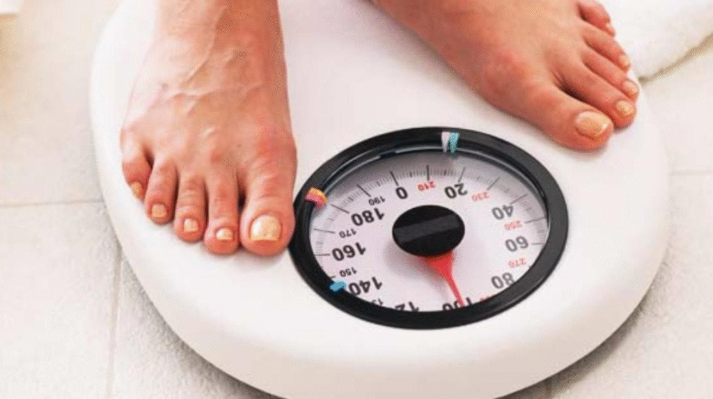 Person standing on a weighing scale to monitor body weight and track fitness progress.
