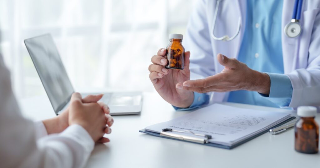 "Doctor explaining a prescription medicine bottle to a patient during consultation, reflecting the professional healthcare approach of Dr. Jai Bhagwan Dhull."